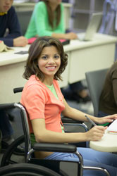 A girl in a wheelchair in a college class.
