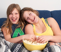 Photo of two young girls sharing popcorn.