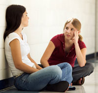 Two girls sitting and talking.