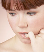 A girl chewing her nail.