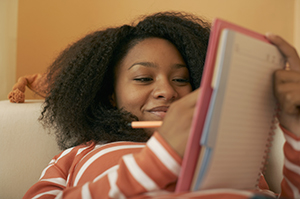 A girl writting in a book.