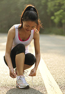 A girl tying her shoe.