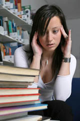 Girls appearing overwhelmed with her schoolwork.