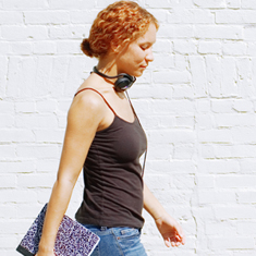 A girl with headphones and a notebook.