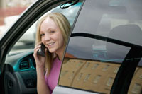 Girl talking on her cell phone while in her car.